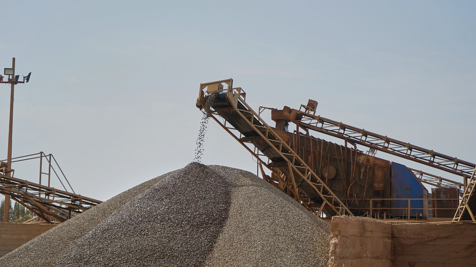 Convoyeur déversant des granulats sur un stock, station de concassage Agré Béton