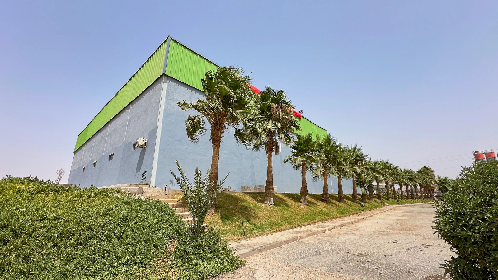 Bâtiment de l’usine Belza Ecotech, bordé de palmiers