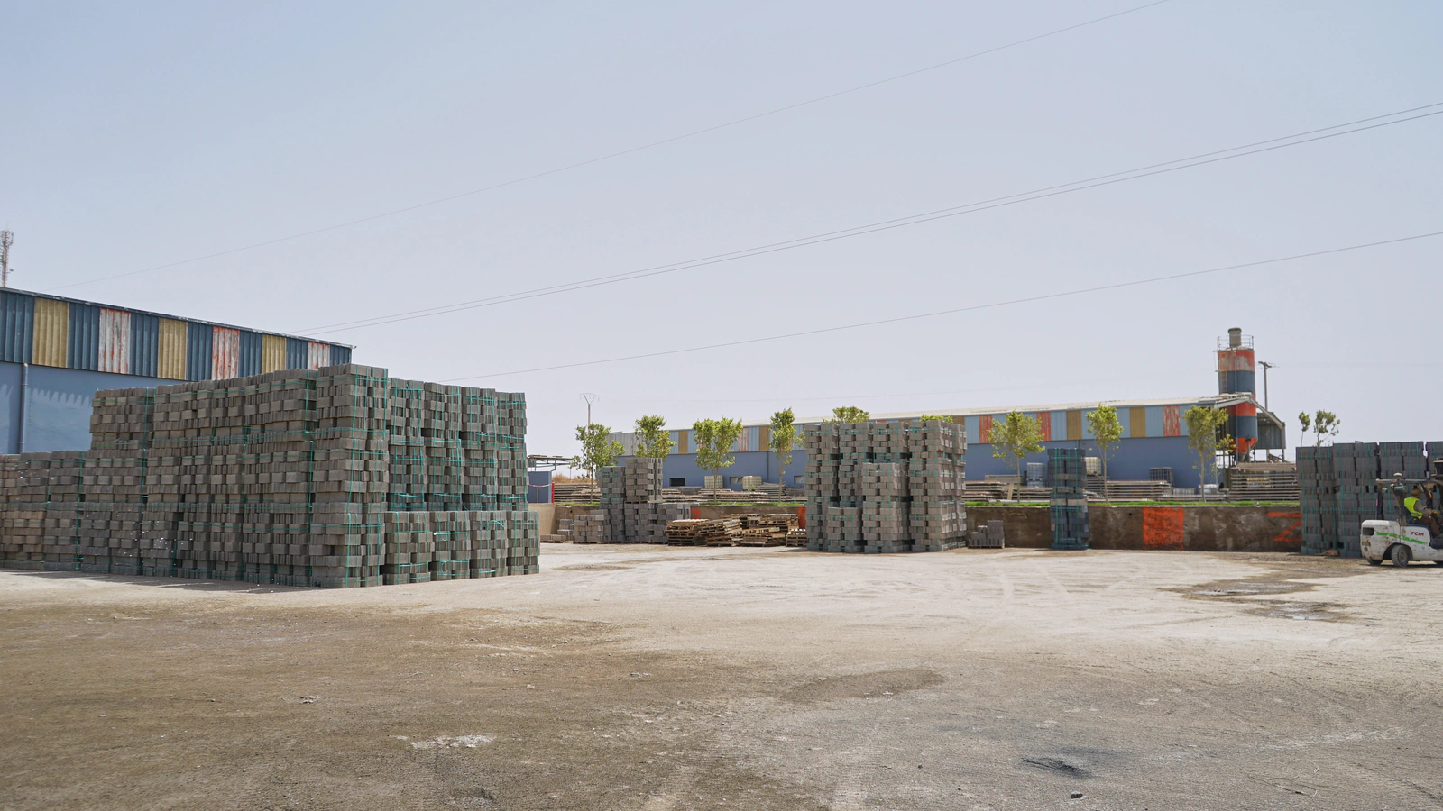 Parc de stockage de blocs en béton devant l’usine Belza Préfa
