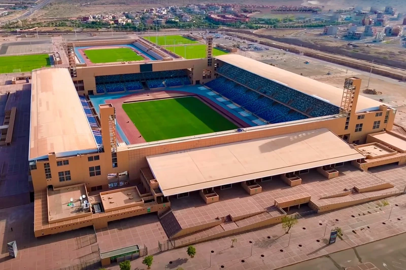 Vue aérienne du Grand Stade de Marrakech : tribunes bleues, pelouse et piste d’athlétisme